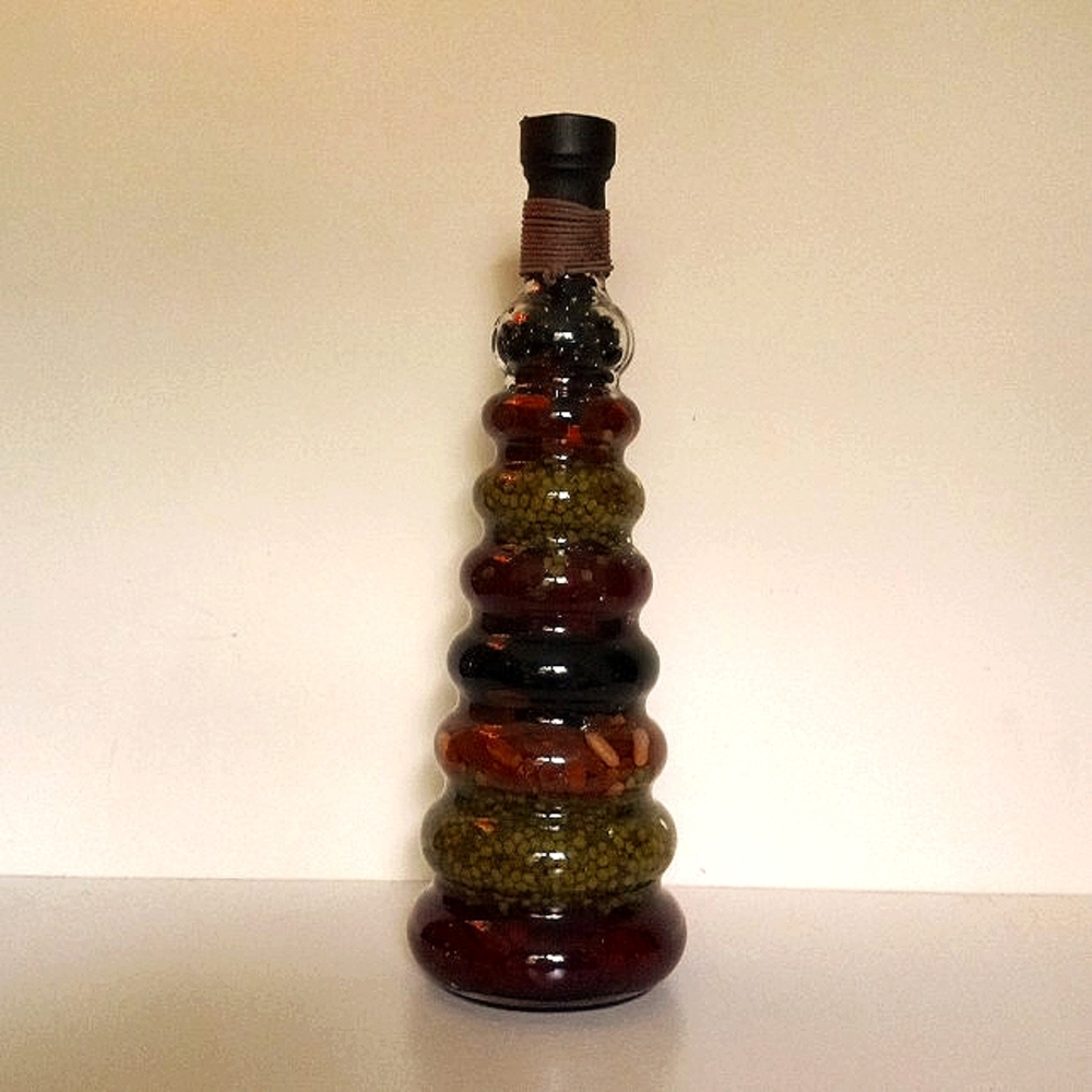 Vinegar infused beans in teardrop glass bottle